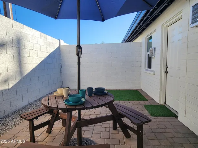 a backyard of a house with table and chairs