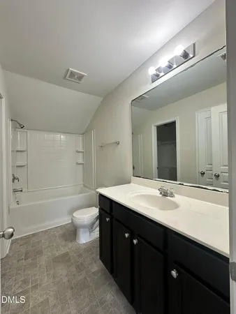 a bathroom with a double vanity sink toilet mirror and bathtub