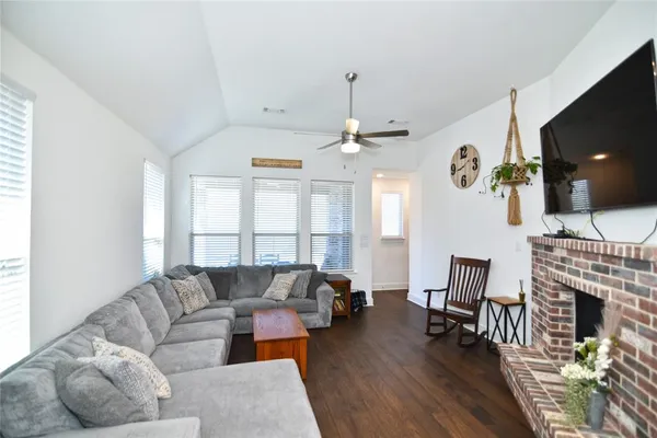a living room with furniture a fireplace and a flat screen tv