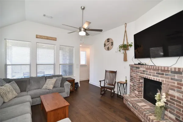 a living room with furniture a fireplace and a flat screen tv