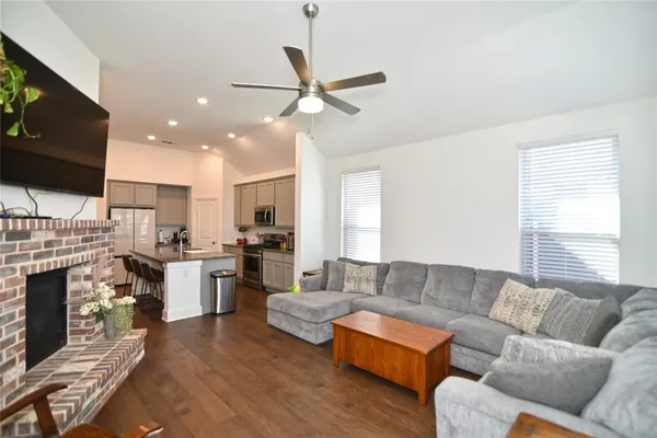 a living room with furniture kitchen view and a fireplace