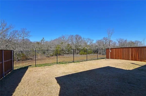 a view of backyard with wooden fence