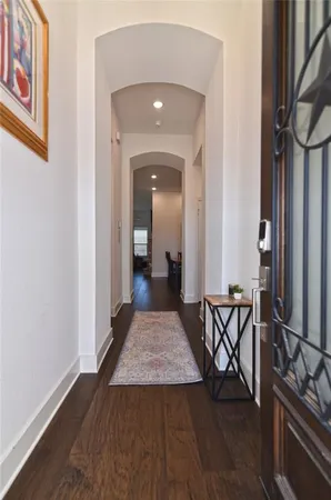 a view of a hallway with wooden floor and furniture