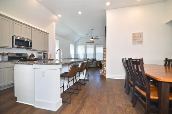 a kitchen with a dining table chairs and a refrigerator
