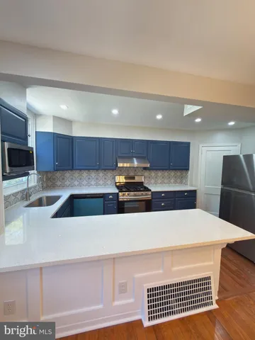 a kitchen with stainless steel appliances kitchen island a refrigerator sink and cabinets