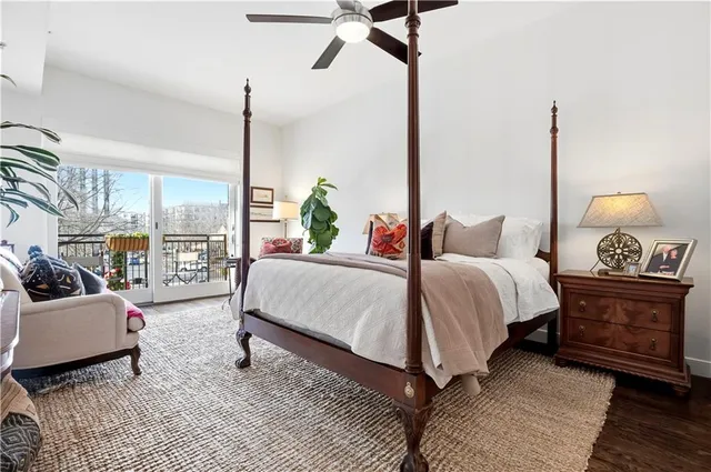 a spacious bedroom with a bed a couch and large window