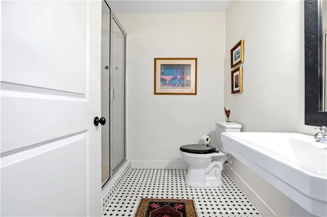 a bathroom with a sink a toilet a mirror and shower