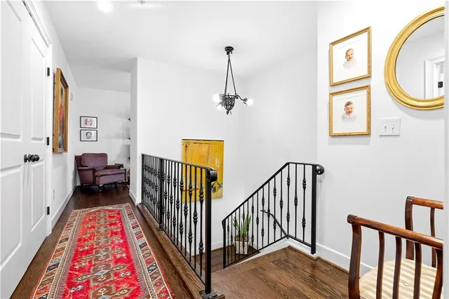 a view of a hallway with wooden floor and staircase