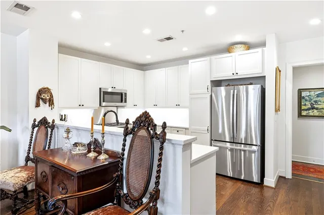 a view of a kitchen with refrigerator and wooden floor