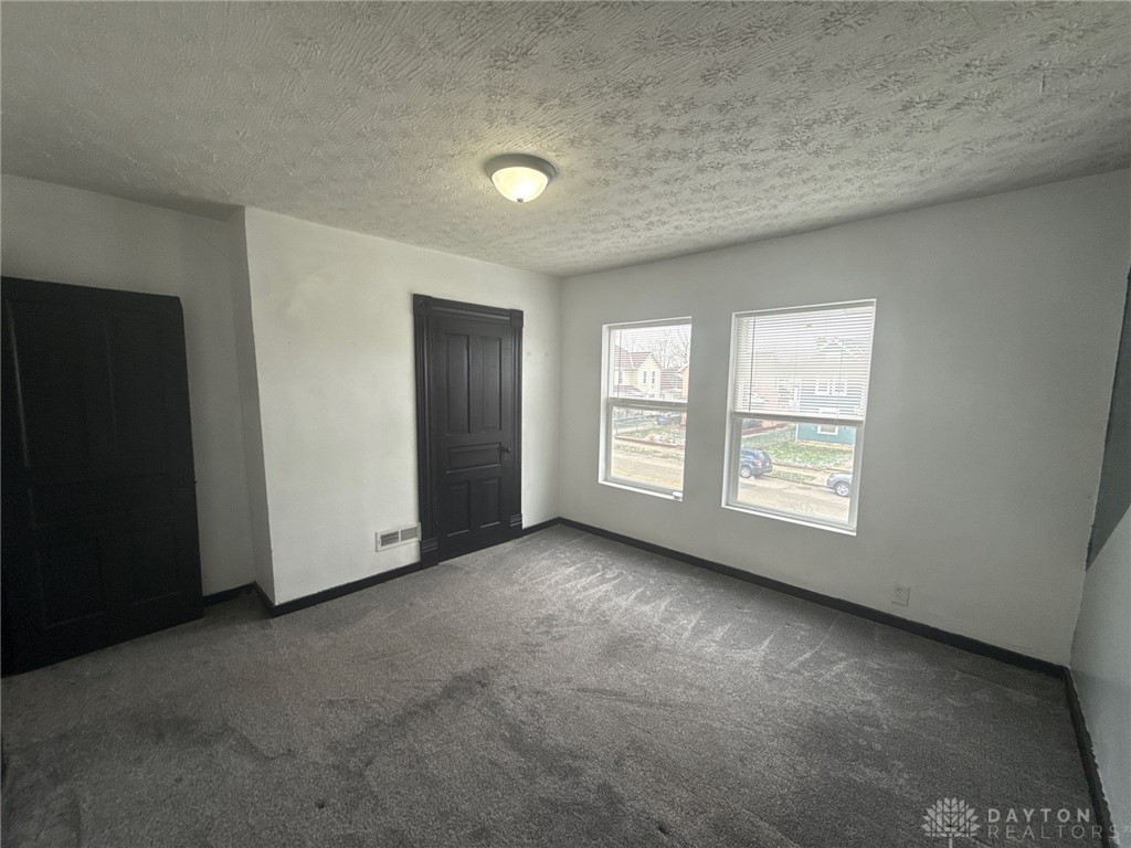 1125 West High Street Springfield, OH 45506 - Photo 22 of 39 This spacious room offers comfort and versatility, featuring ample natural light and plush carpeting.