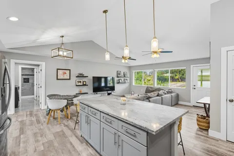 a view of a kitchen counter top space a sink appliances and living room view