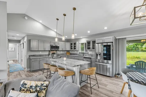 a kitchen with refrigerator and chairs