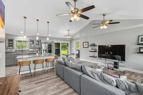 a living room with furniture and a flat screen tv with wooden floor