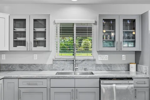 a kitchen with granite countertop sink and window