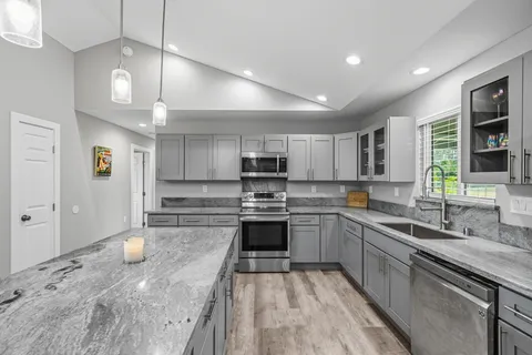 a kitchen with stainless steel appliances granite countertop a sink and cabinets