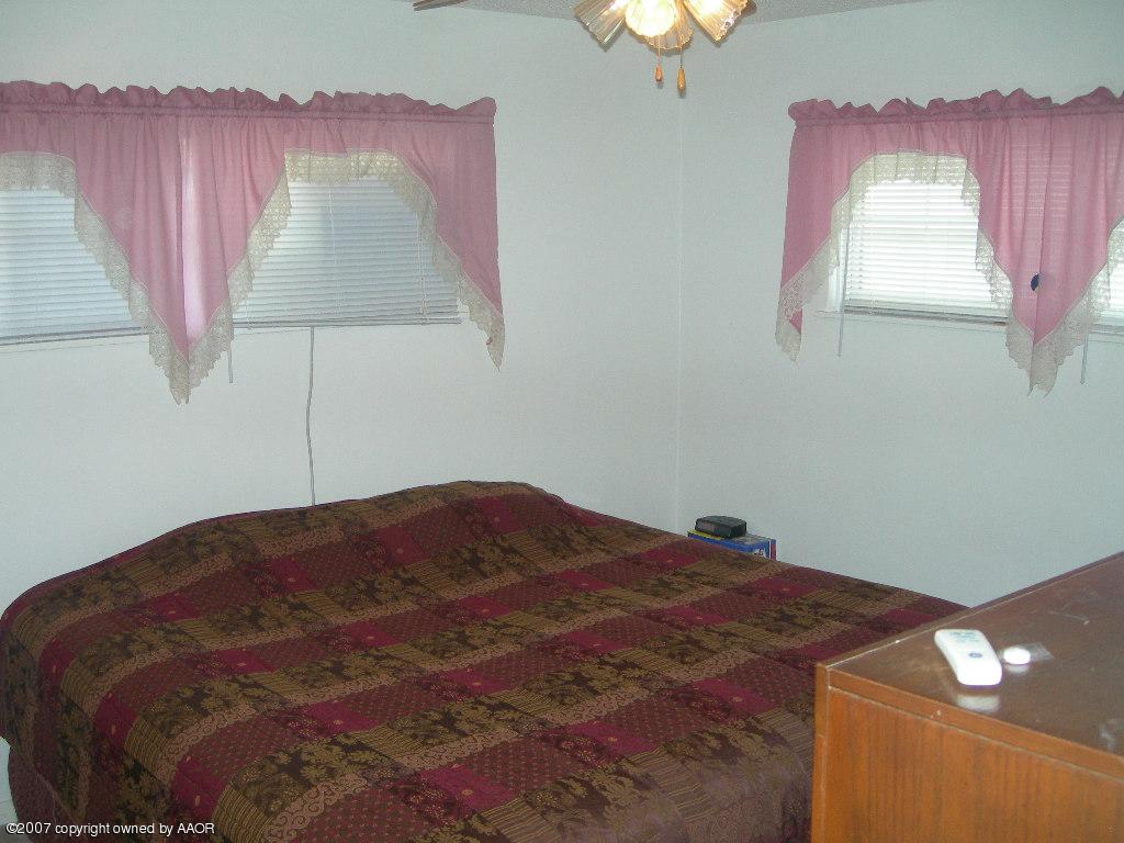 4601 Cline Road Amarillo, TX 79110 - Photo 5 of 9 a bedroom with a bed and a lamp
