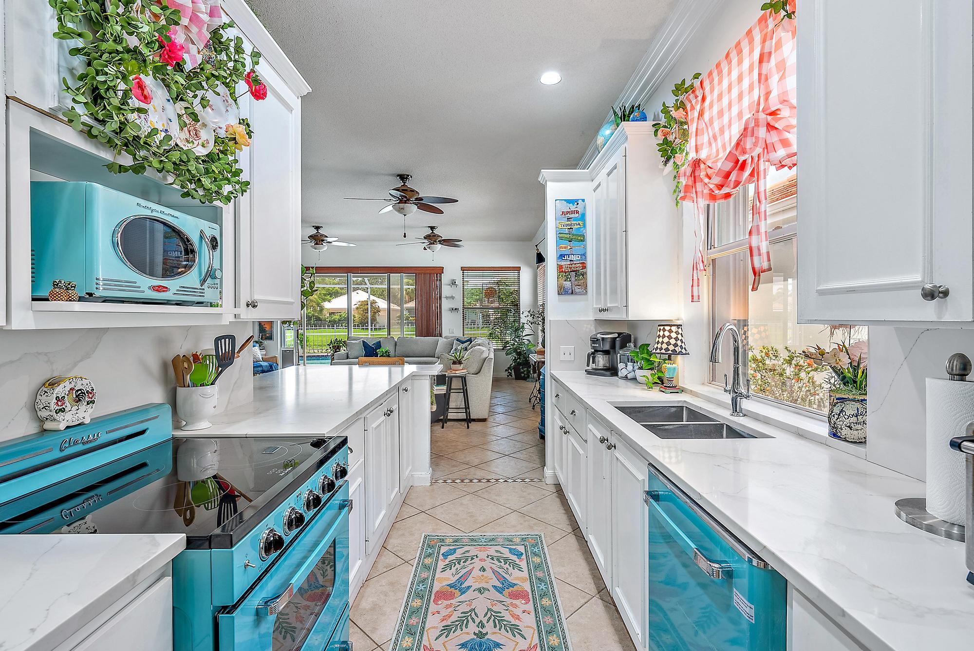 115 South Hampton Drive Jupiter, FL 33458 - Photo 14 of 27 a kitchen with kitchen island a sink stove and cabinets