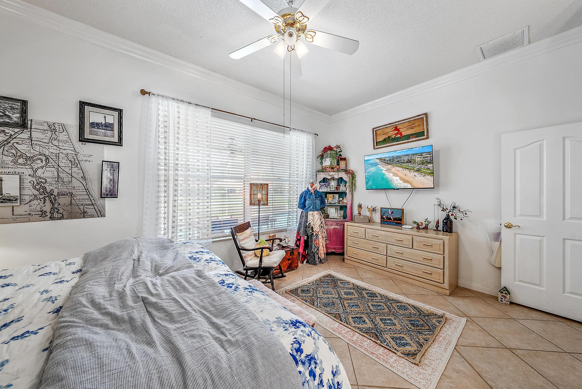 115 South Hampton Drive Jupiter, FL 33458 - Photo 22 of 27 a bedroom with a bed and a chandelier