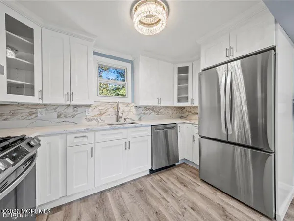 a kitchen with granite countertop a refrigerator sink and cabinets