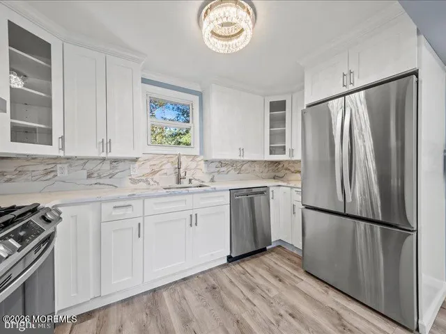 a kitchen with granite countertop a refrigerator sink and cabinets