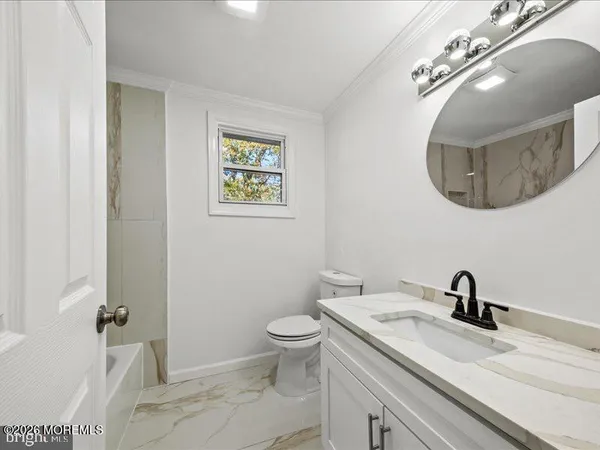 a bathroom with a toilet a sink and mirror