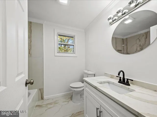 a bathroom with a toilet a sink and mirror