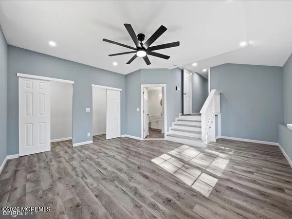 a view of a livingroom with a ceiling fan and wooden floor