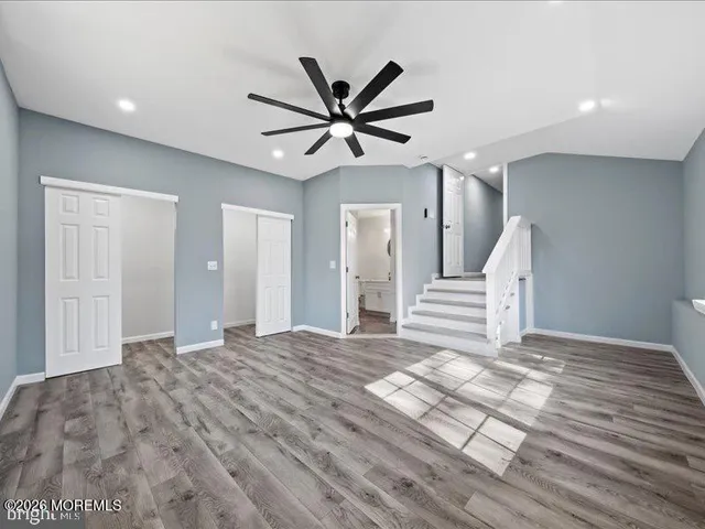 a view of a livingroom with a ceiling fan and wooden floor