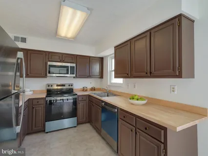 a kitchen with stainless steel appliances granite countertop a sink stove and microwave