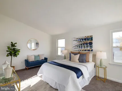 a bedroom with a large bed and a potted plant