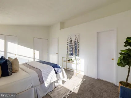 a bedroom with a bed and a potted plant