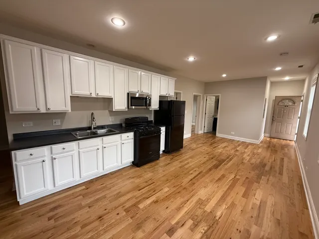 a kitchen with granite countertop a refrigerator sink and cabinets