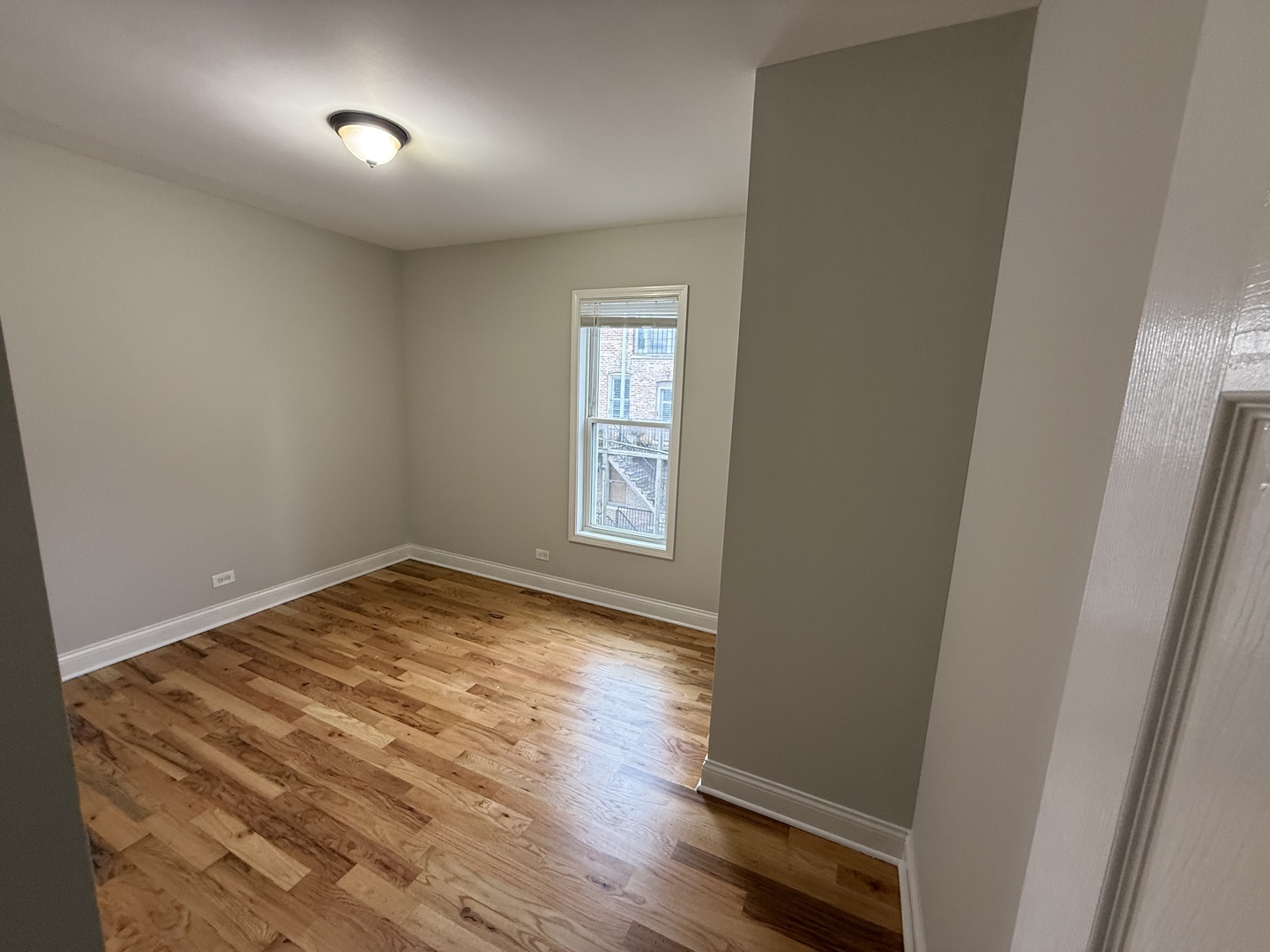 712 South Aberdeen Street, Unit 3B Chicago, IL 60607 - Photo 5 of 9 an empty room with wooden floor and windows