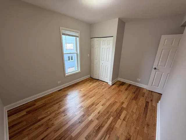 an empty room with wooden floor and window