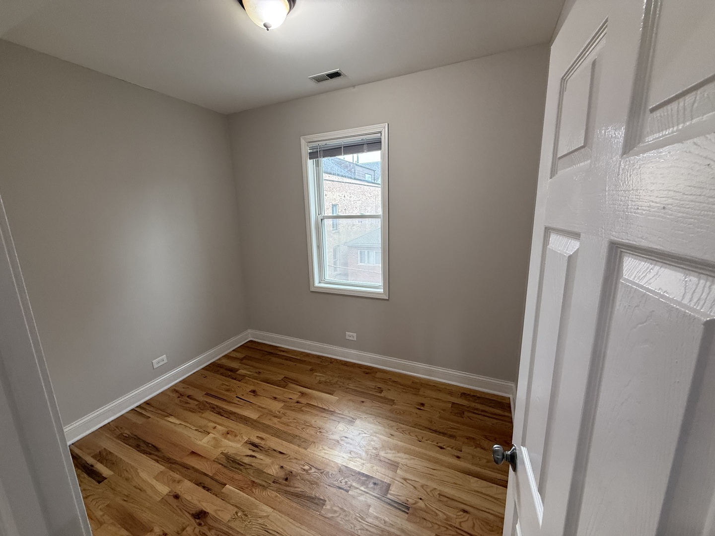 712 South Aberdeen Street, Unit 3B Chicago, IL 60607 - Photo 9 of 9 an empty room with wooden floor cabinet and windows