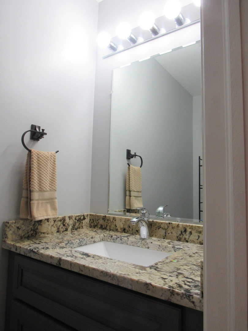696 Western Lane Addison, IL 60101 - Photo 18 of 36 a bathroom with a granite countertop sink and a mirror