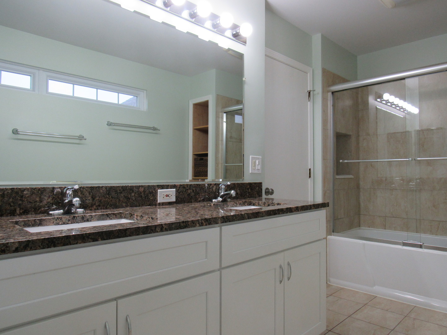 696 Western Lane Addison, IL 60101 - Photo 20 of 36 a bathroom with a sink a large mirror and a bathtub