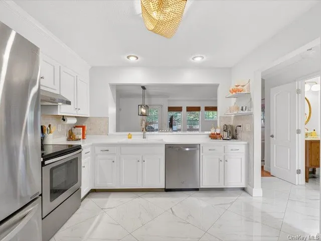 a kitchen with white cabinets and white appliances