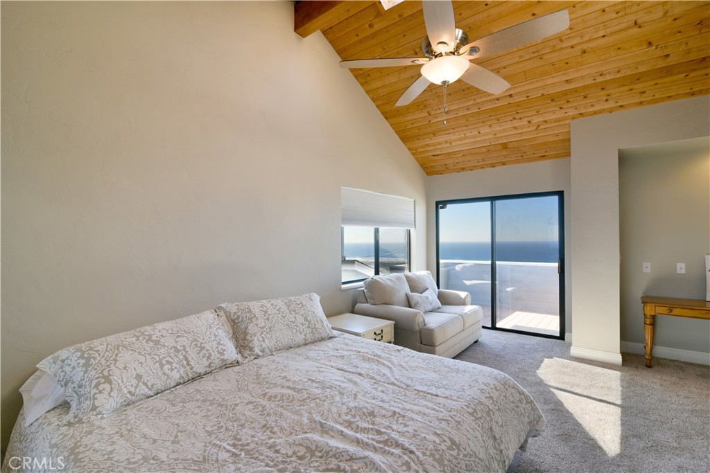 2640 Maple Morro Bay, CA 93442 - Photo 16 of 29 a bedroom with a large bed and a chandelier