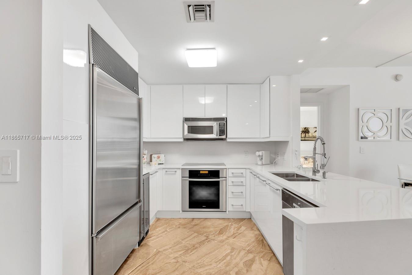 901 Brickell Key Boulevard, Unit 1409 Miami, FL 33131 - Photo 13 of 39 a kitchen with a sink stainless steel appliances and cabinets