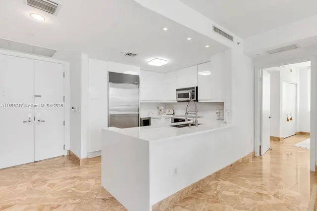 a kitchen with stainless steel appliances a refrigerator sink and stove