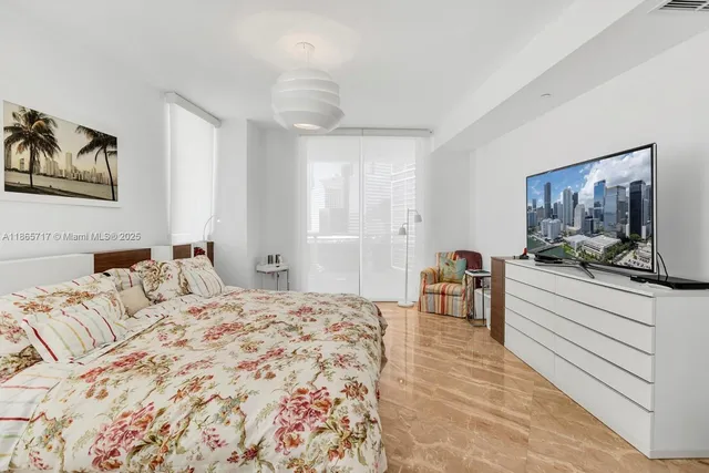 a bedroom with a large bed and a chandelier