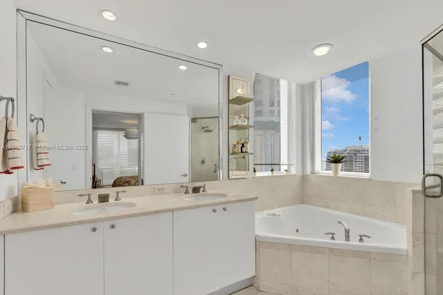 a bathroom with a bathtub a sink and a large mirror