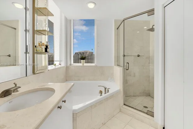 a bathroom with a tub sink shower and mirror
