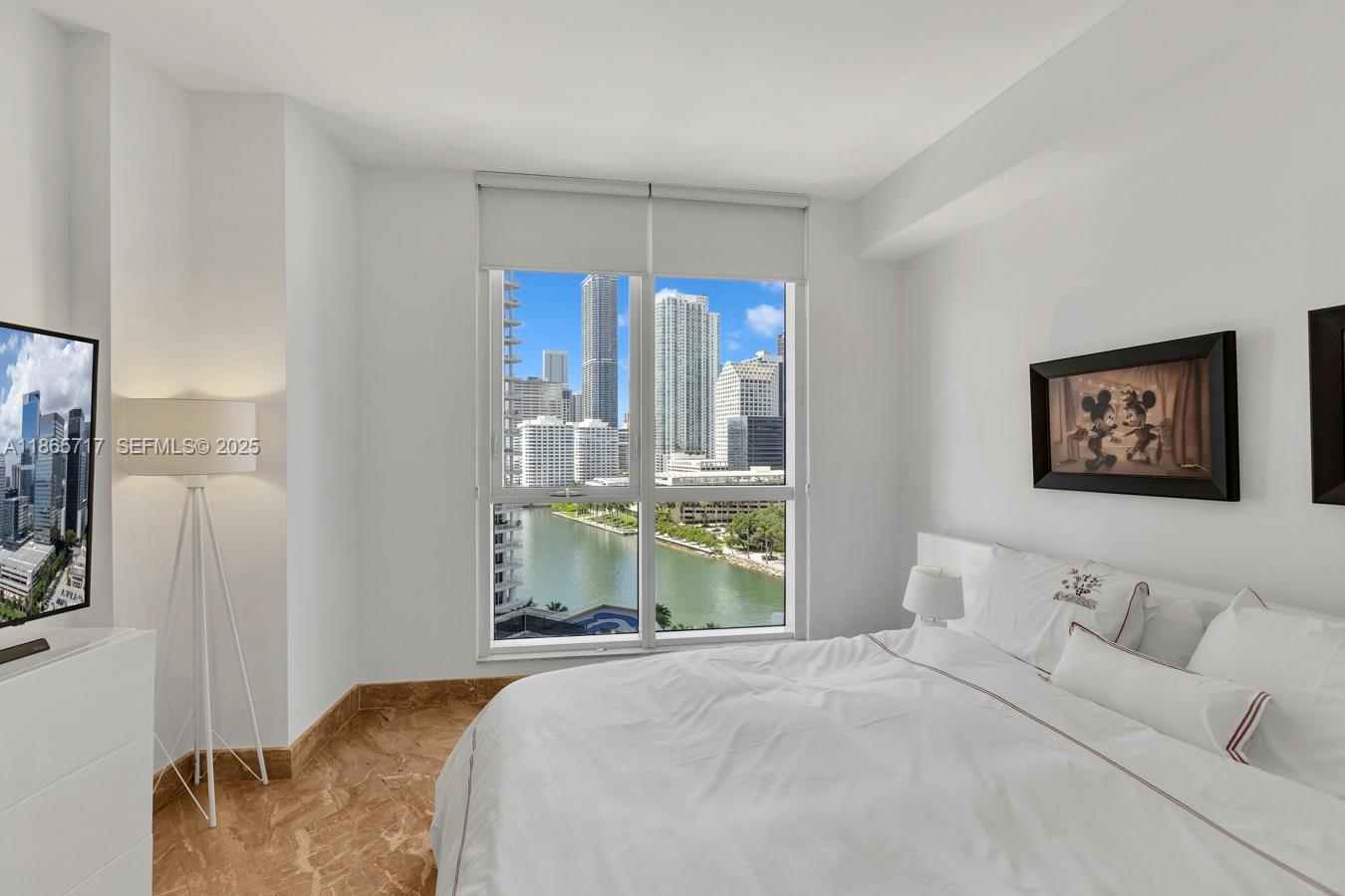 901 Brickell Key Boulevard, Unit 1409 Miami, FL 33131 - Photo 23 of 39 a bedroom with a bed and glass window