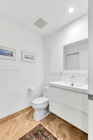 a bathroom with a sink toilet and a mirror