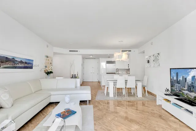 a living room with furniture and a dining table with kitchen view