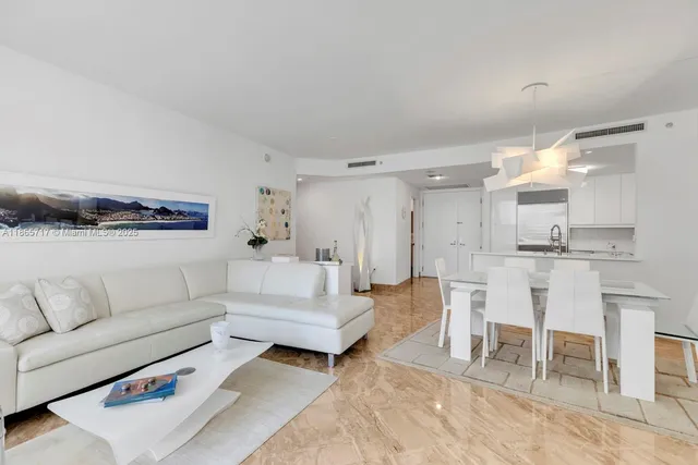 a living room with furniture and a view of kitchen
