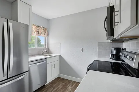 a kitchen with a sink a refrigerator and cabinets
