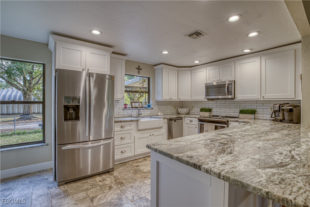19740 Gottarde Road North Fort Myers, FL 33917 - Photo 2 of 12 a kitchen with stainless steel appliances granite countertop a refrigerator a stove a sink and a microwave